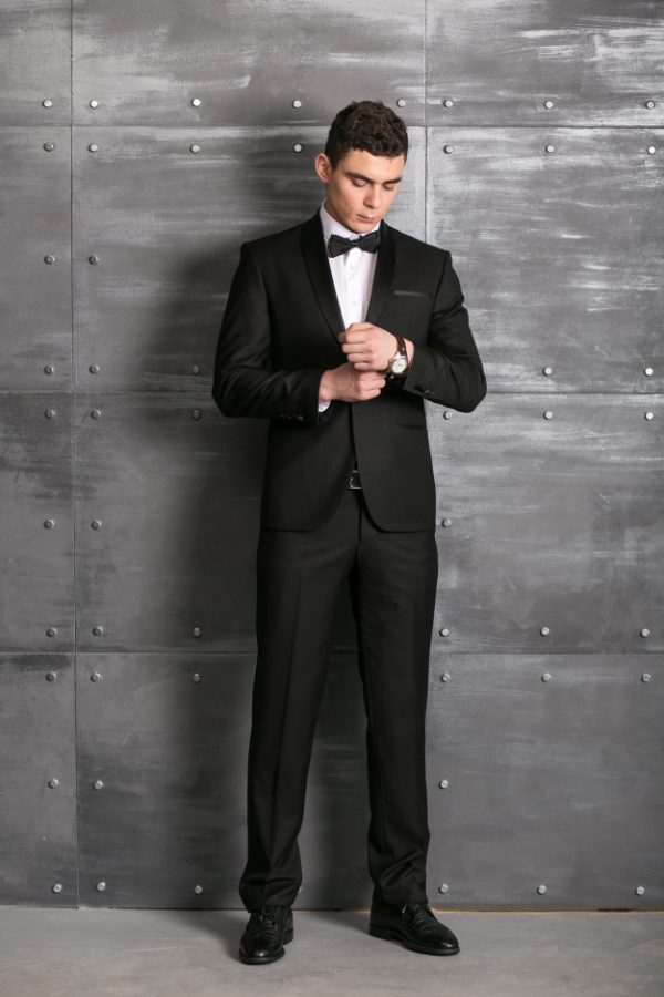 Traje negro satinado, silueta ajustada.